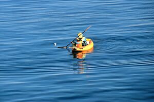 A man in a kayak in the middle of a body of water